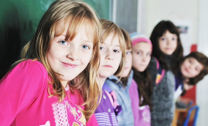 Für eine starke Klasse Eine Gruppe von Mädchen lehnt mit dem Rücken an eine Tafel und blicken über ihre rechte Schulter freundlich in die Kamera.