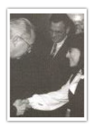 Förderpreis zur "Prävention und Gesundheitsförderung 1994" von der Leipziger-Halleschen-Nationalen-Stiftung. Ein älterer Herr schüttelt die Hand eine dunkelhaarigen Frau. Das Bild ist schwarz weiß.