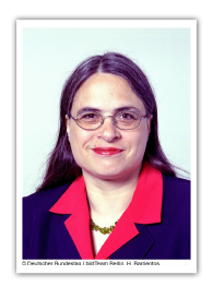 Christa Nickels übernimmt Schirmherrschaft Porträt Foto einen brünetten Frau mit Brille, die eine rote Bluse unter dem Sacko trägt.